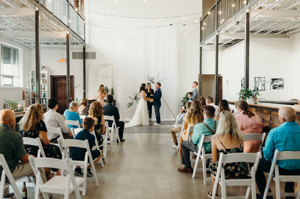 Guests seated beside a wedding aisle under the mezzanine