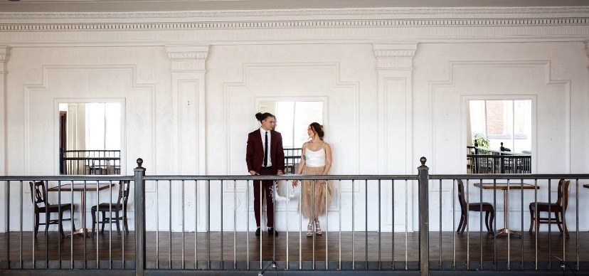 A couple standing on the historic mezzanine balcony