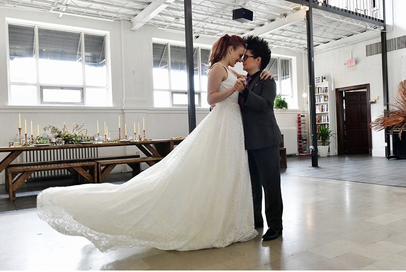 Two brides sharing a kiss on the dance floor