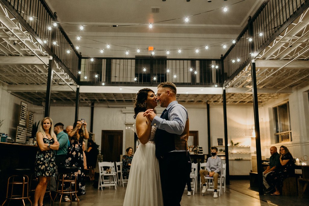 A couple celebrating beneath the evening string lights