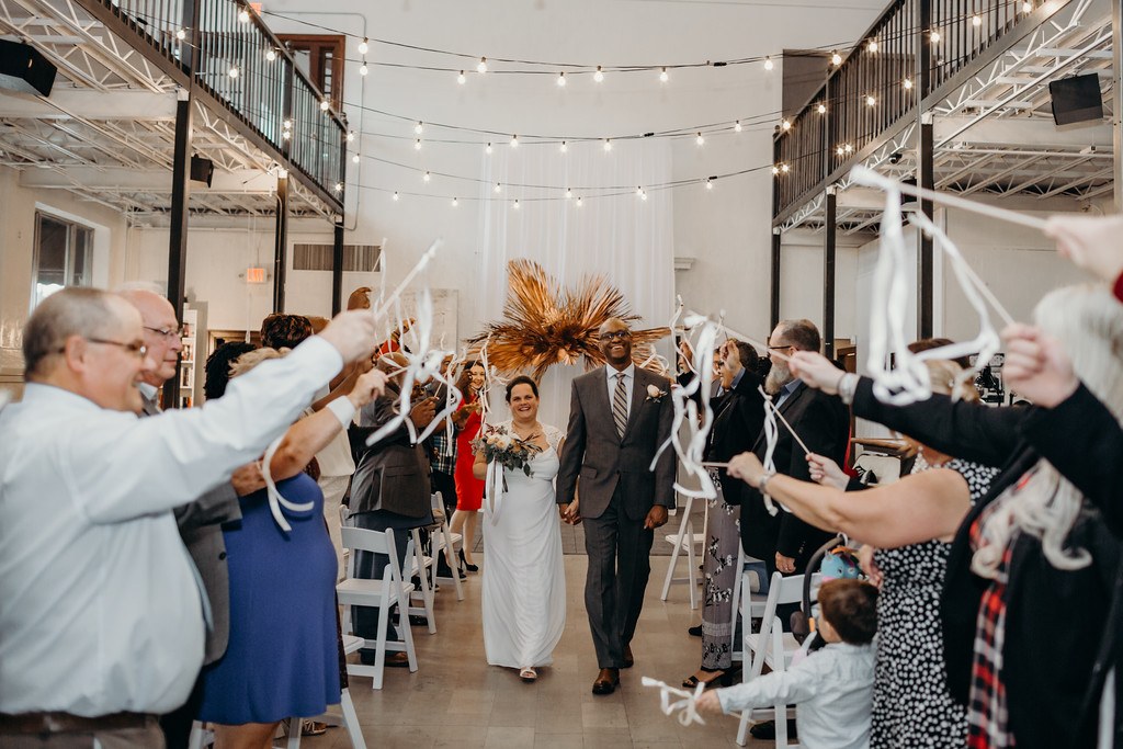 Wedding guests celebrating a couple with a ribbon send-off