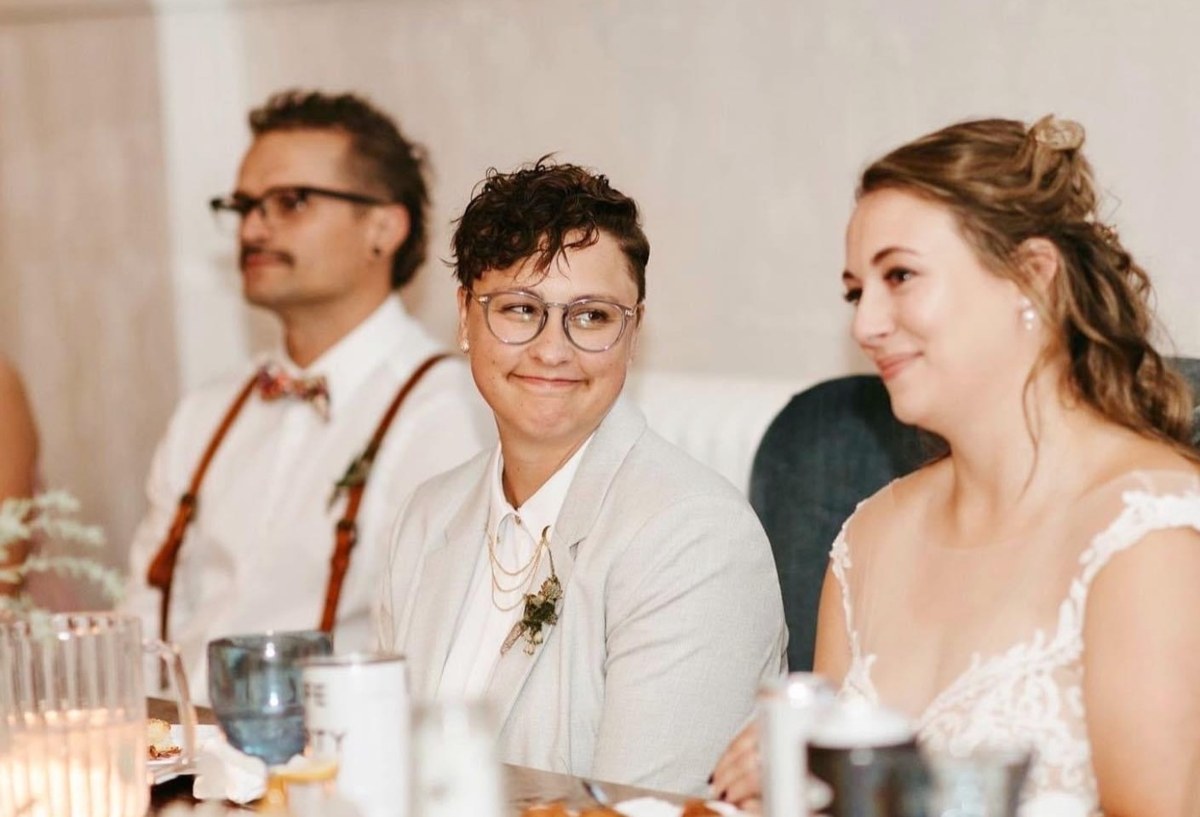 A couple and a guest laughing at the head table
