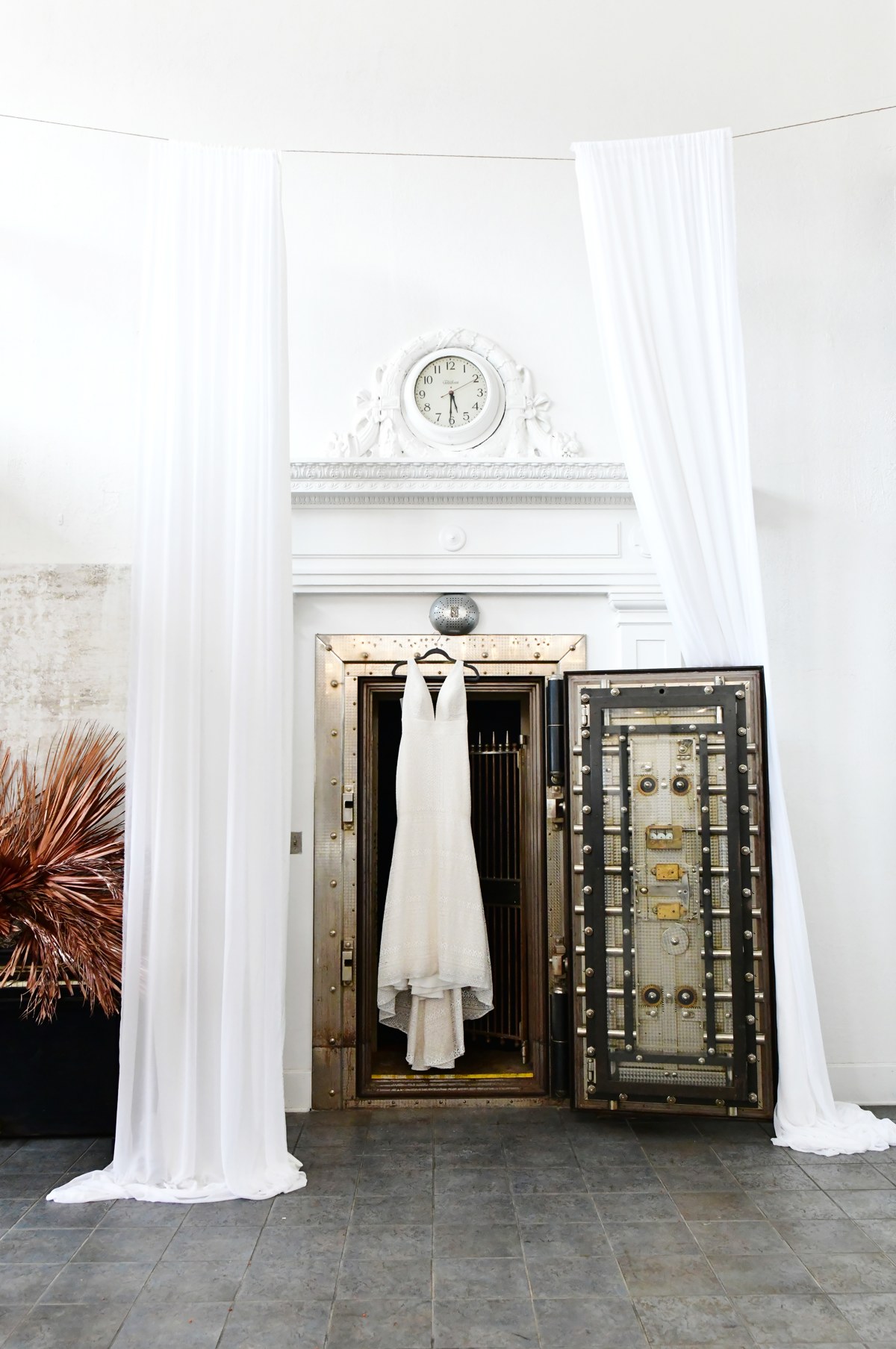 The open historic vault door framed by white drapes